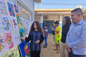 A estudante Wevellyn mostra ao secretário-adjunto Fernando Tinoco e a coordenadora Wilma Camilo o desenho de sua autoria  - Foto por: Alecy Alves/Sesp-MT