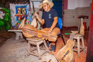 ¿¿Alcides Ribeiro esculpiu uma viola de cocho durante a abertura da Casa Tur  - Foto por: Taiguara Luciano/Sedec