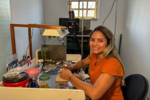 A empreendedora Flávia Dias, proprietária da Helisa Davi Joias, investiu em uma máquina para polir e produzir suas próprias peças. Crédito - Gabrielle Assis | Desenvolve MT.